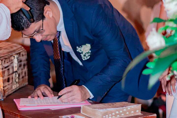 Noivo assinando documento no casamento religioso com efeito civil