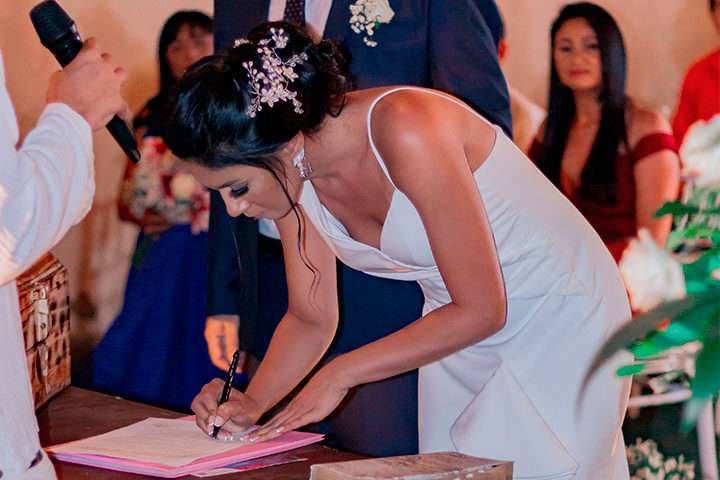 Noiva assinando documento em casamento religioso com efeito civil