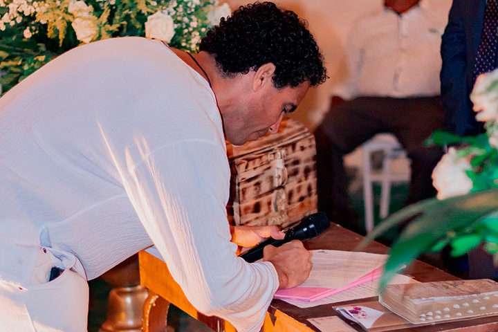 Homem assinando documento de casamento religioso