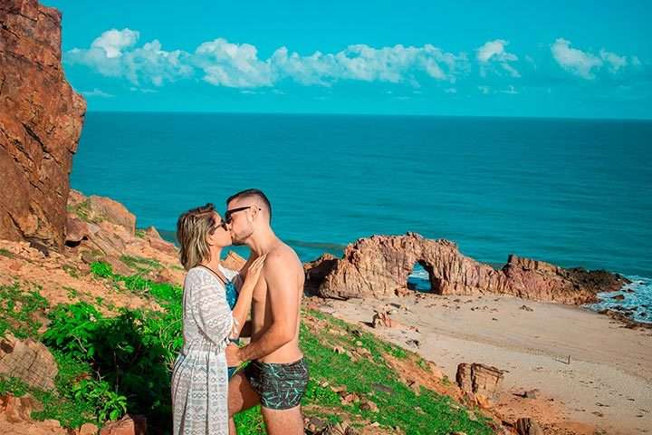 Casal de noivos se beijando na Pedra Furada, em Jericoacoara