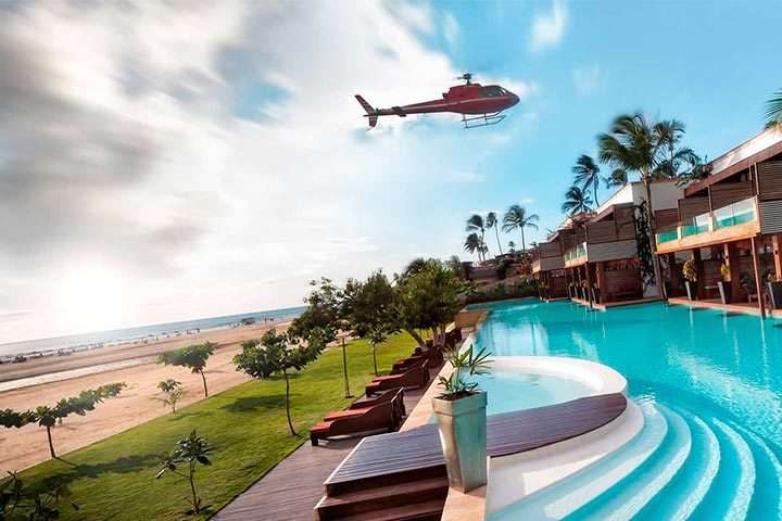 Helicóptero voando sobre hotel na praia de Jericoacoara