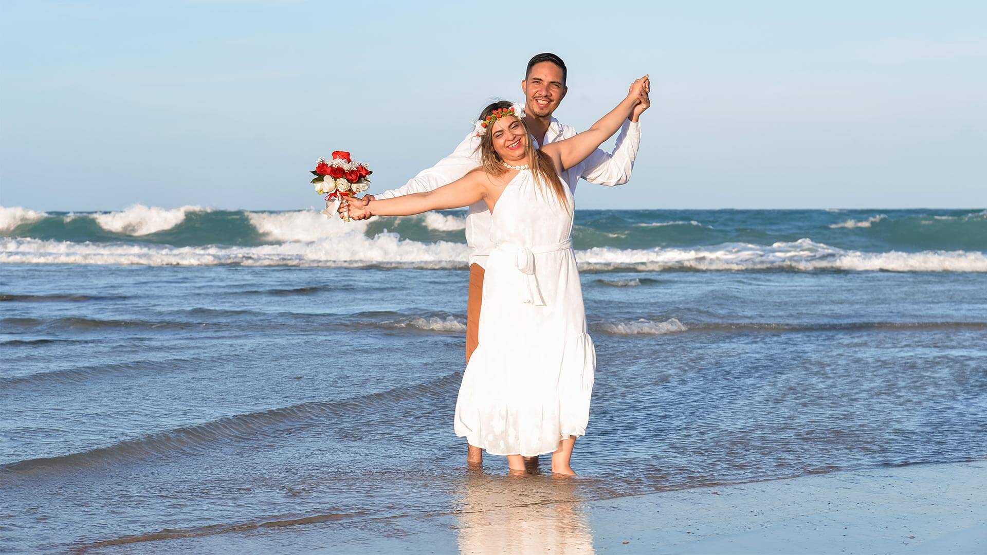Homem e mulher abraçados, na praia, fazaendo renovação de votos de casamento