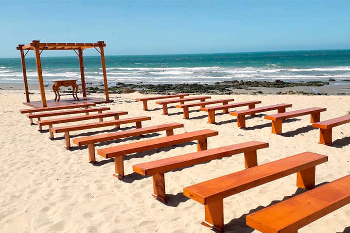 Bancos de madeira e altar de casamento na praia