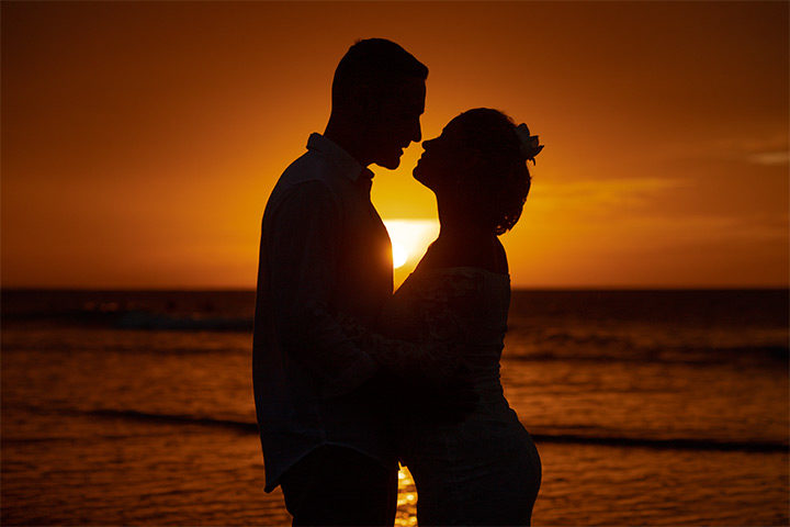 Casal de noivos na praia, no pôr do sol