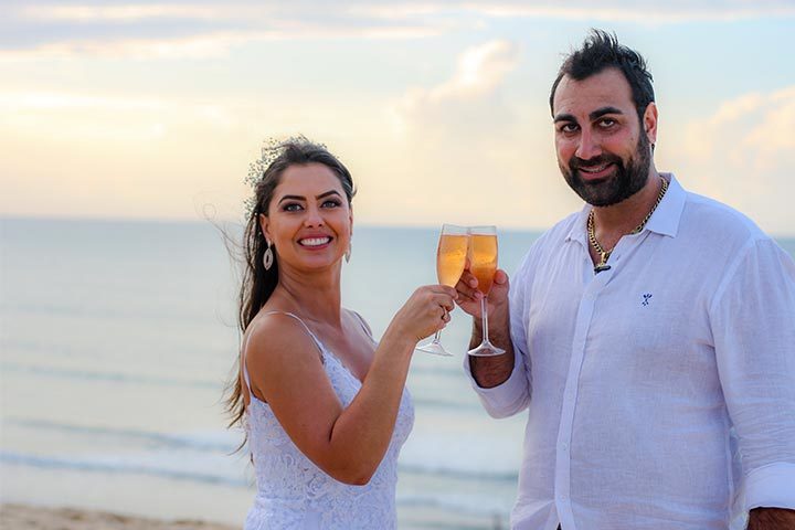Casal de noivos brindando Elopement na praia