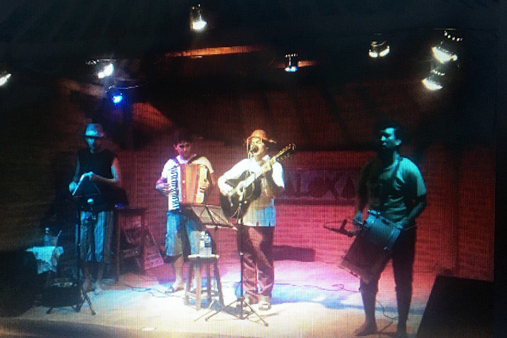 Banda de forró tocando em palco com som e iluminação