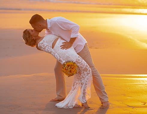 Noivo beijando a noiva no pôr do sol em Jericoacoara