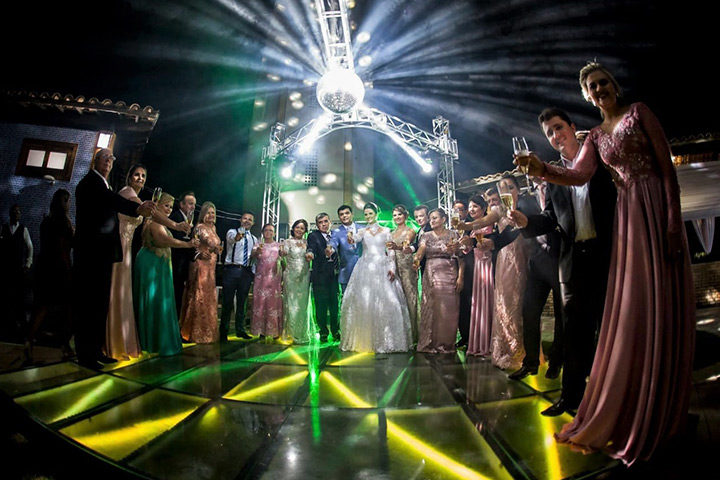 Convidados dançando em tablado de vidro e led colorido