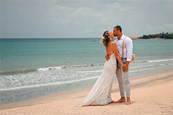 Casal de noivos se beijando na praia