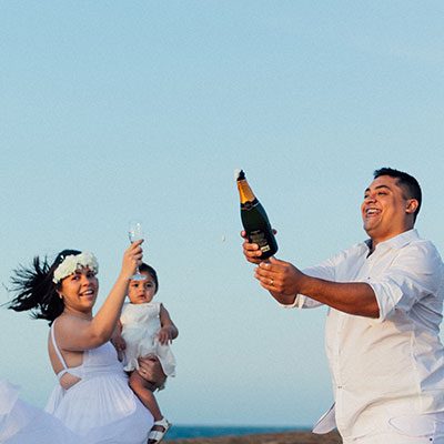 Casal de noivos brindando na praia